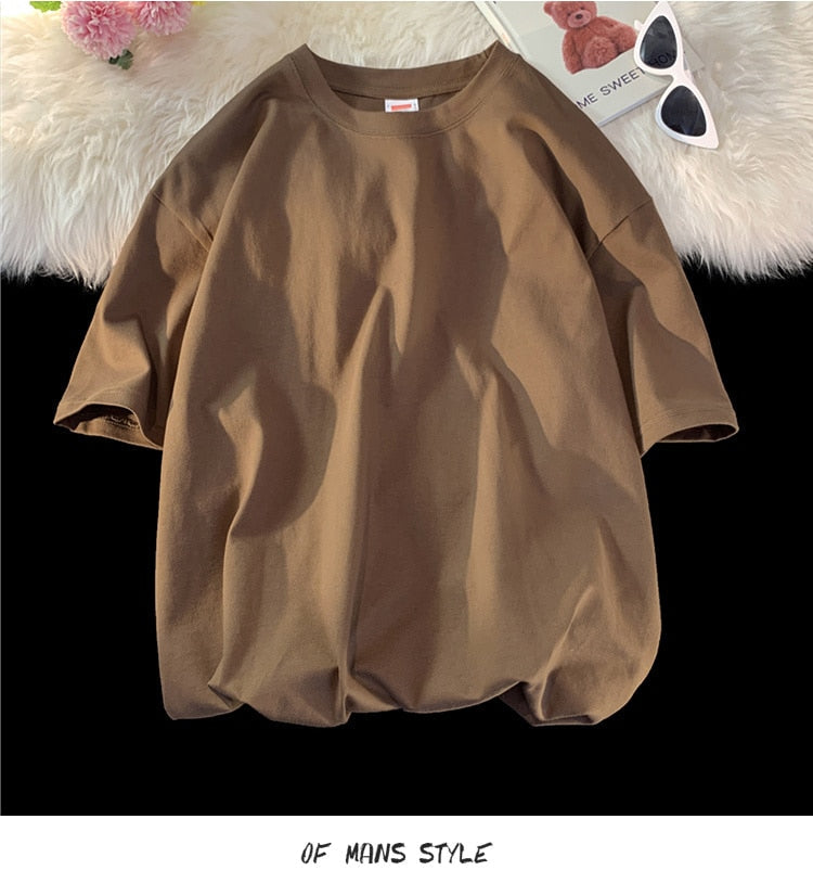 Antonios Oversized Casual Cotton T-Shirt in brown displayed on a cozy background with sunglasses and decor.