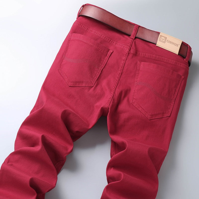 Back view of red business casual jeans with belt, featuring elastic cotton denim fabric.