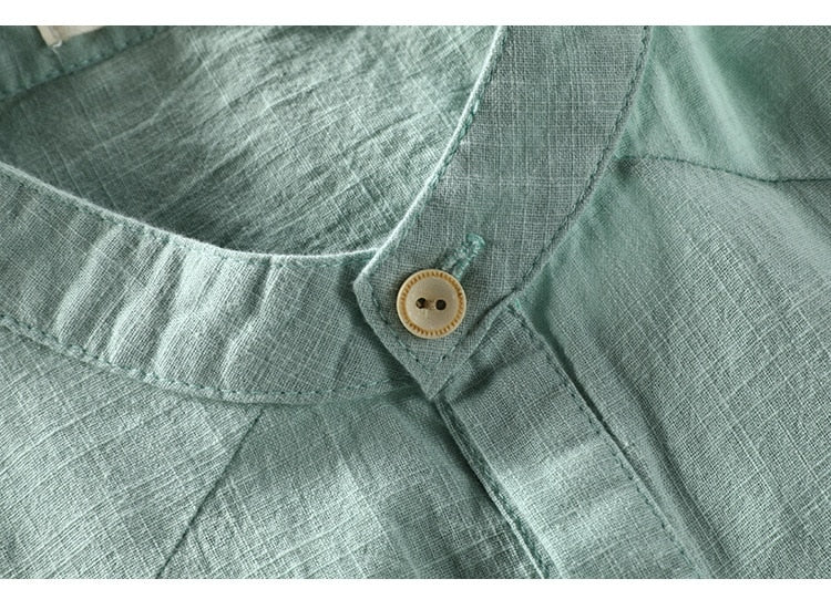 Close-up of green London T-Shirt collar with button detail, made from 100% organic cotton and linen.
