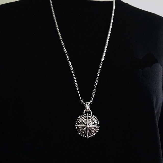 Antonios Vintage Stainless Steel Necklace with Compass Pendant on Black Background.