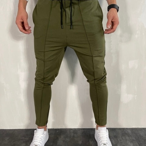 Men's green Antonios Streetwear Joggers with white sneakers displaying relaxed fit and drawstring waist.