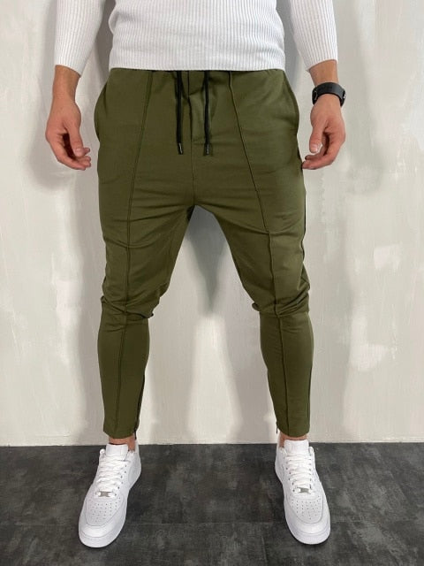 Men's green Antonios Streetwear Joggers with white sneakers displaying relaxed fit and drawstring waist.