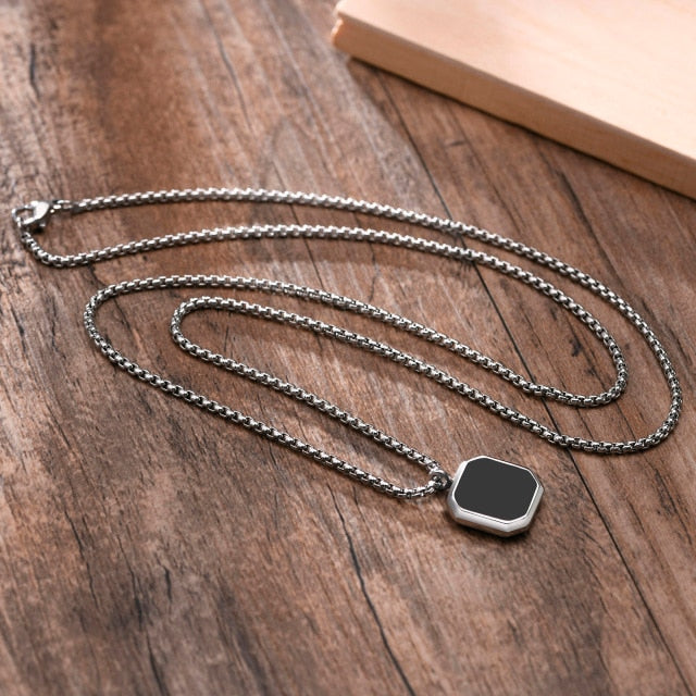Antonios Rubin Stainless Steel Necklace for Men on wooden surface.