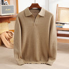 Beige sweater on a hanger with a blurred indoor background