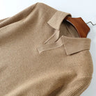Beige sweater on a wooden hanger against a white background