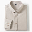 A folded light beige long-sleeve button-down shirt with a pointed collar and matching buttons, displayed on a clean white background.