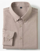 A folded long-sleeve button-up shirt in a light taupe-beige color, displayed on a clean white background with two small inset detail images on the right showing a cotton graphic and fabric texture.