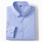 A light blue long-sleeve button-down dress shirt neatly folded, showing the collar, front buttons, and a folded cuff on a clean white background.