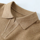 Close-up of a brown knitted sweater with a collar on a light background