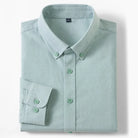 A folded light green sage long-sleeve button-down shirt with a pointed collar and matching buttons, displayed on a clean white background.