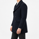 Herringbone double breasted coat with wide lapels in navy blue — male model side view