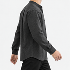 Relaxed checked shirt with curved front seams in dark gray — side view on a male model