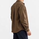 Relaxed checked shirt with curved front seams in brown — side view on a male model
