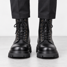 Black leather lace up combat boots in black, front view on a model