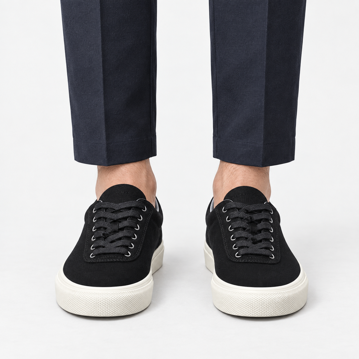 Canvas lace up sneakers with contrast soles in black, front view on a model