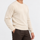 Fine knit wool crew neck sweater in cream, side view on a model