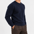Fine knit wool crew neck sweater in navy, side view on a model