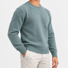 Fine knit wool crew neck sweater in stone green, side view on a model