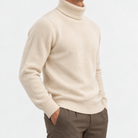 Fine knit wool turtleneck sweater in cream, side view on a model