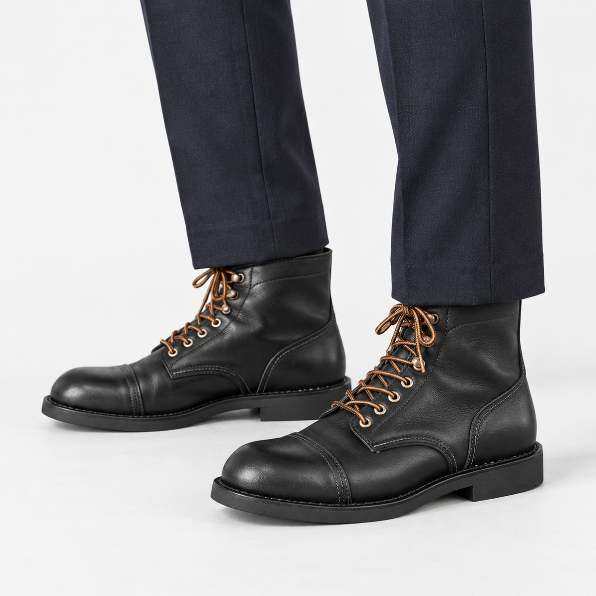Leather cap toe lace up boots in black, side view on a model