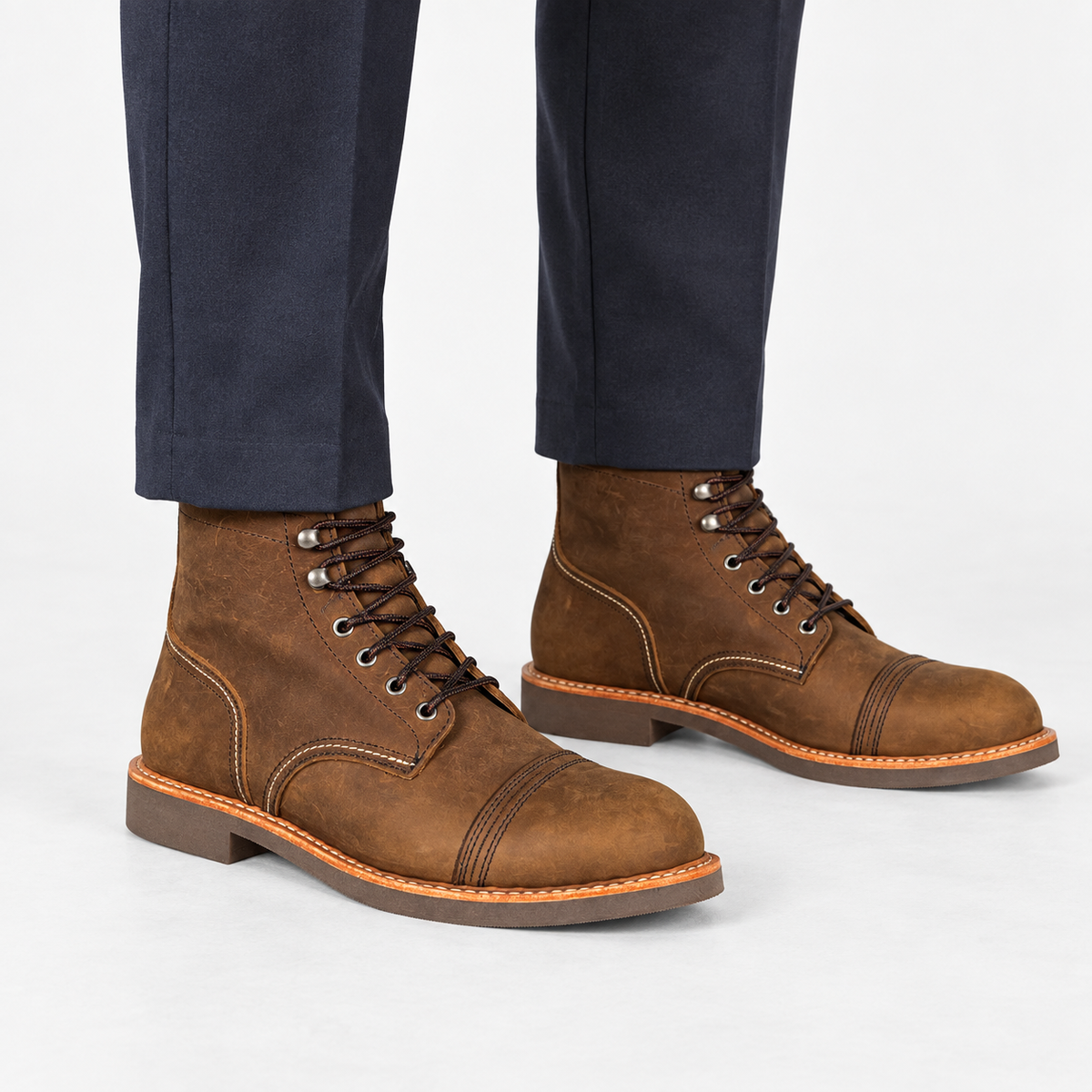 Leather cap toe lace up boots in brown, side view on a model