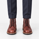 Leather cap toe lace up boots in burgundy, front view on a model