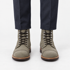 Leather cap toe lace up boots in gray suede, front view on a model