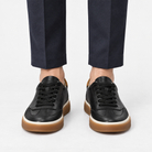 Leather court sneakers with gum soles in black, front view on a model