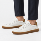 Leather court sneakers with gum soles in white, side view on a model