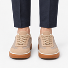 Leather low top sneakers with chunky gum soles in sand, front view on a model