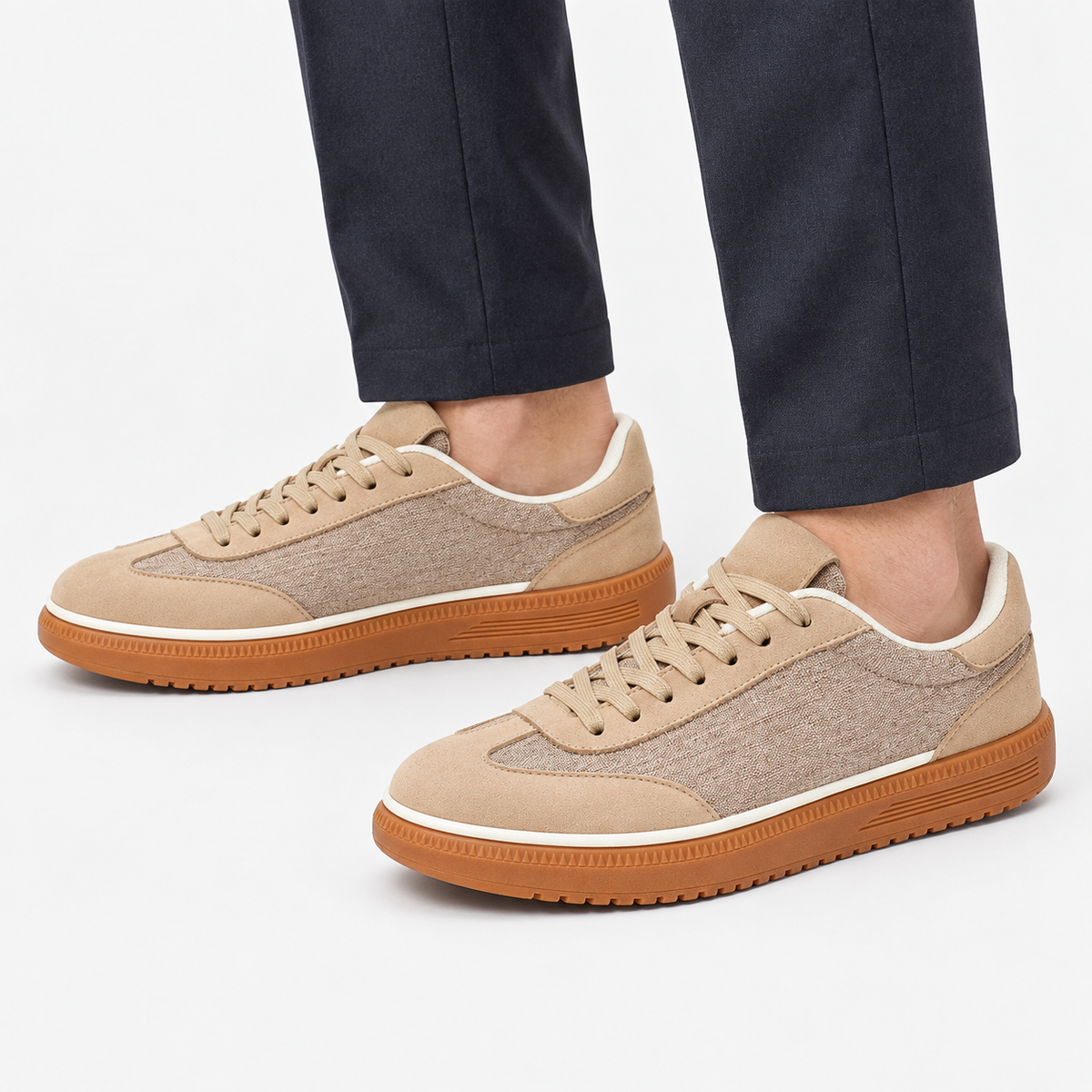 Leather low top sneakers with chunky gum soles in sand, side view on a model