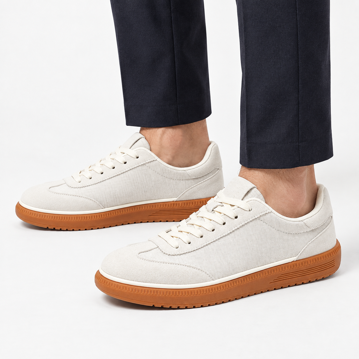 Leather low top sneakers with chunky gum soles in white, side view on a model