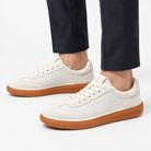 Leather low top sneakers with chunky gum soles in white, side view on a model