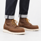 Leather moc toe wedge sole boots in brown, side view on a model