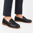 Leather penny loafers with contrast soles in black leather, side view on a model