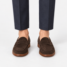Leather penny loafers with contrast soles in dark brown suede, front view on a model