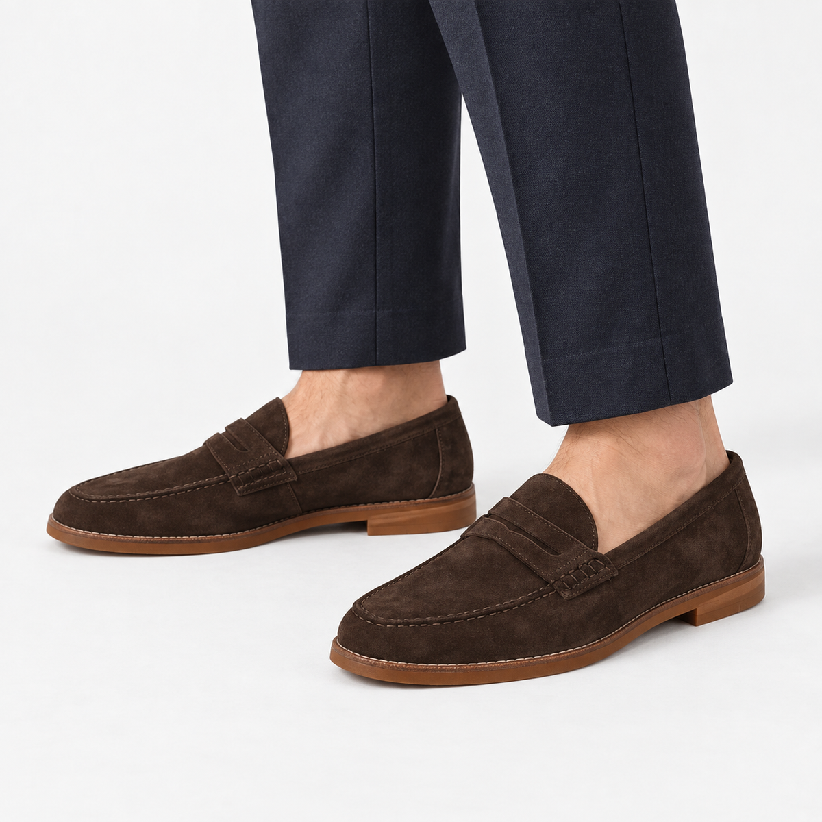 Leather penny loafers with contrast soles in dark brown suede, side view on a model