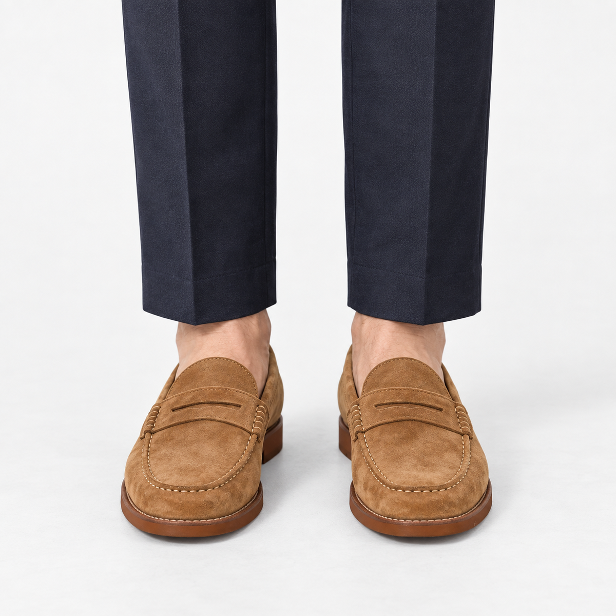 Leather penny loafers with contrast soles in tan suede, front view on a model