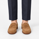 Leather penny loafers with contrast soles in tan suede, front view on a model