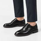 Leather plain toe derby shoes in black, side view on a model