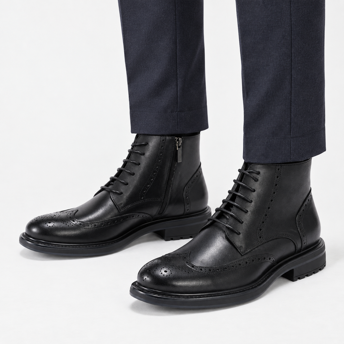 Leather wingtip boots with side zips in black, side view on a model