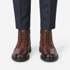 Leather wingtip boots with side zips in coffee, front view on a model