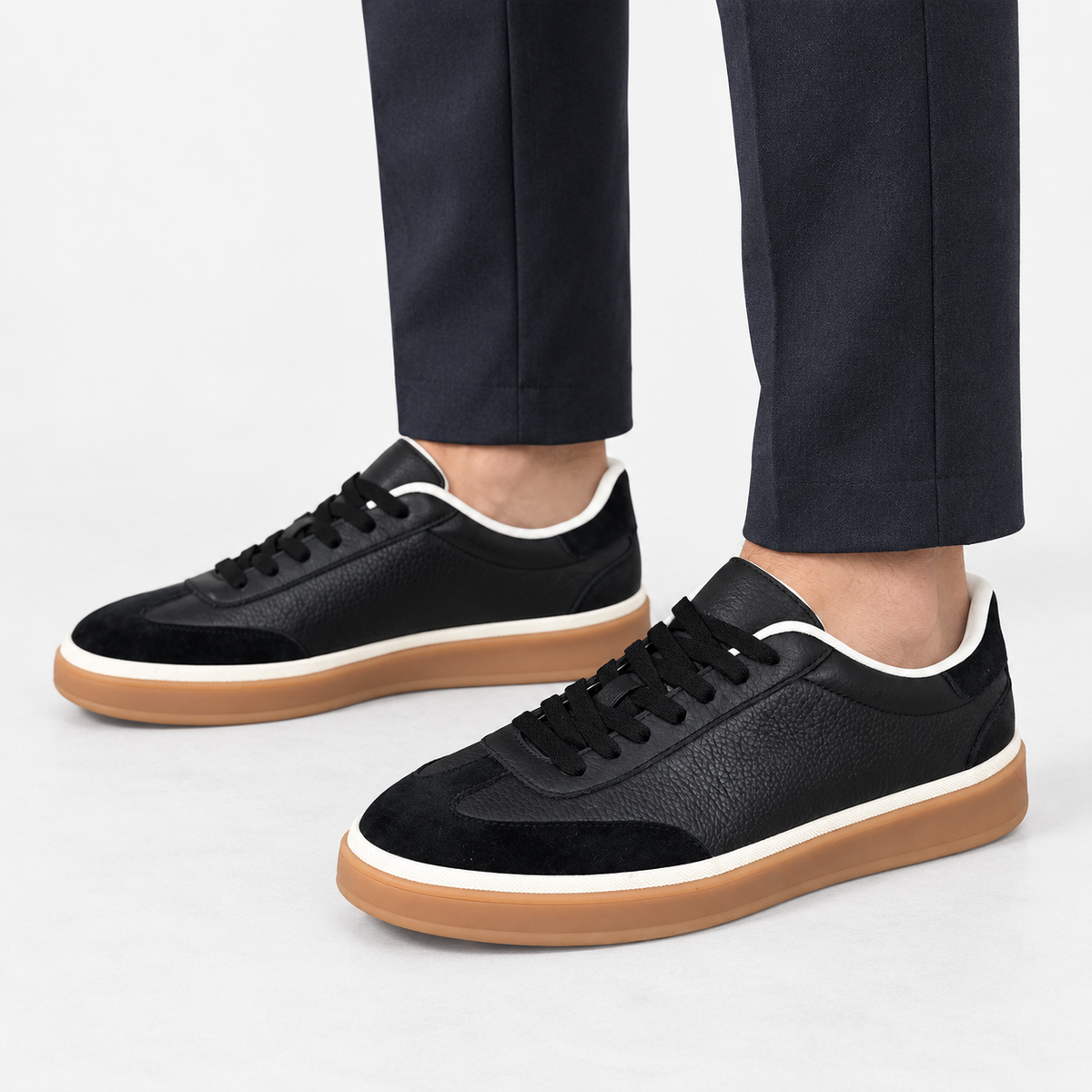 Retro leather sneakers with contrast soles in black gum sole, side view on a model