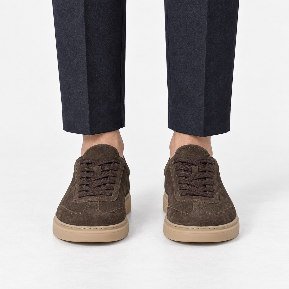 Suede cupsole sneakers with tonal laces in dark brown, front view on a model