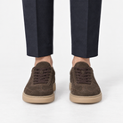 Suede cupsole sneakers with tonal laces in dark brown, front view on a model