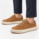 Suede panel low top sneakers in tan, side view on a model
