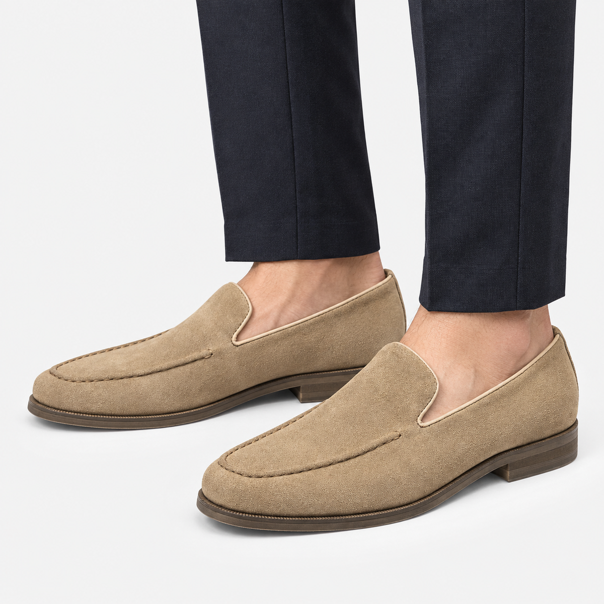 Suede slip on loafers with apron stitching in sand, side view on a model
