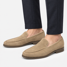 Suede slip on loafers with apron stitching in sand, side view on a model