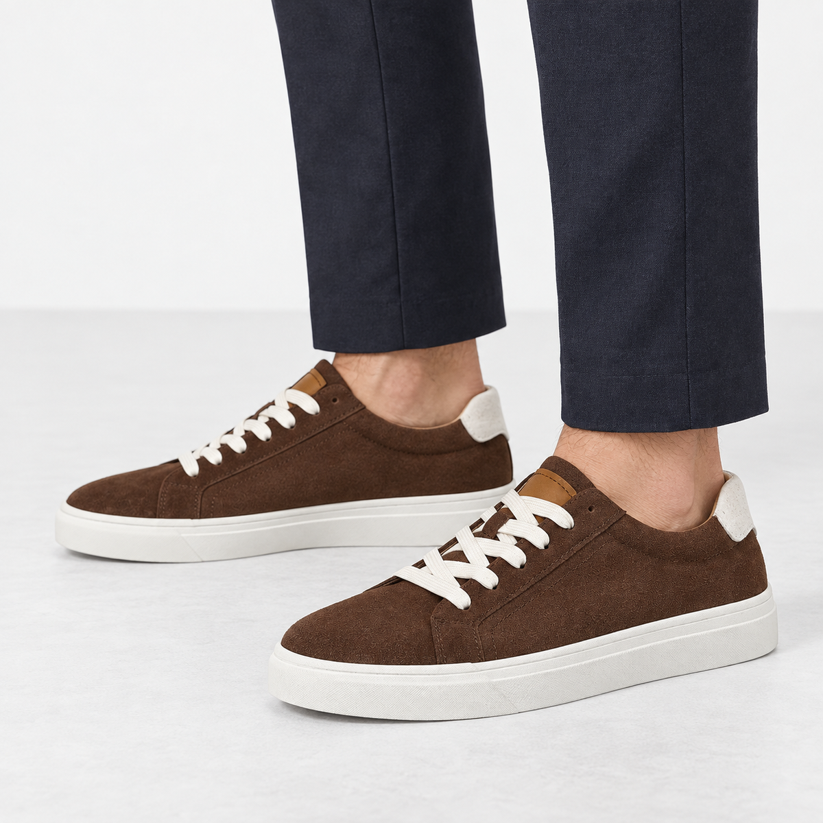 Suede sneakers with contrast heel tabs in brown, side view on a model