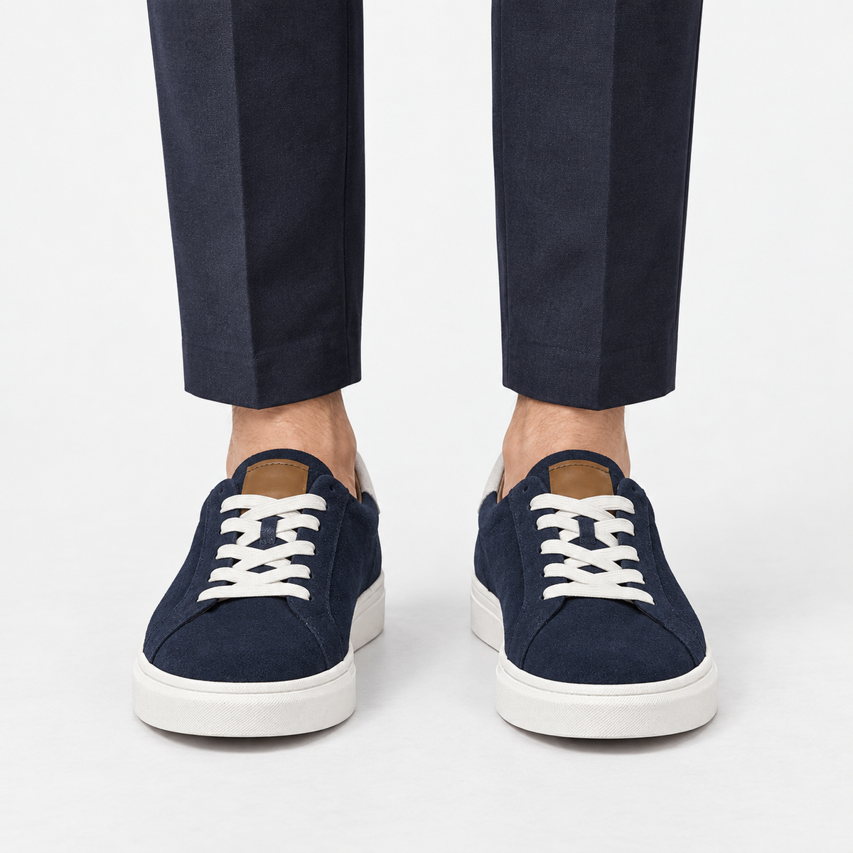 Suede sneakers with contrast heel tabs in navy, front view on a model